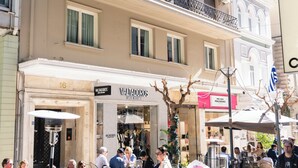 A multi-story building with balconies, air conditioning units, and a café at the ground level. - Athens Heart Gem Lux Apartment (Athens)