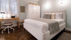 A bedroom with a bed, desk, chair, wardrobe, and a window with curtains. - Athens Heart Gem Lux Apartment (Athens)