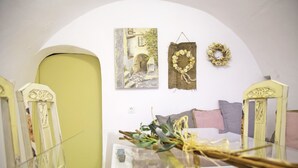 A room with a bed, a sofa, and a wall with two paintings and two wreaths. - Areopolis Art Apartment (East Mani)