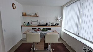 Cocina compacta con comedor, un reloj en la pared y un adorno con forma de estrella.