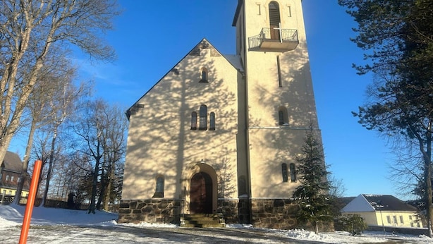 Una iglesia con campanario, muros de piedra y un reloj.