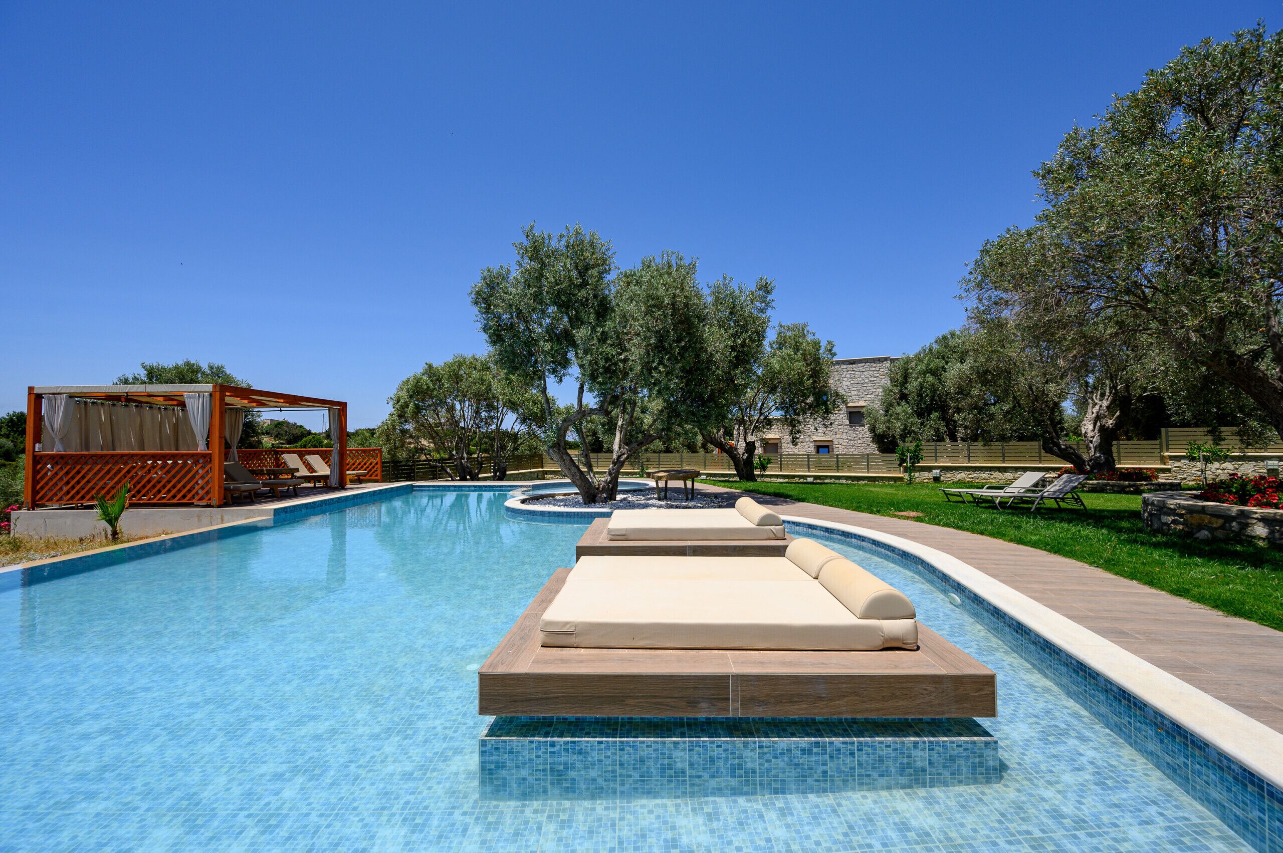 A swimming pool with lounge chairs and a wooden deck.