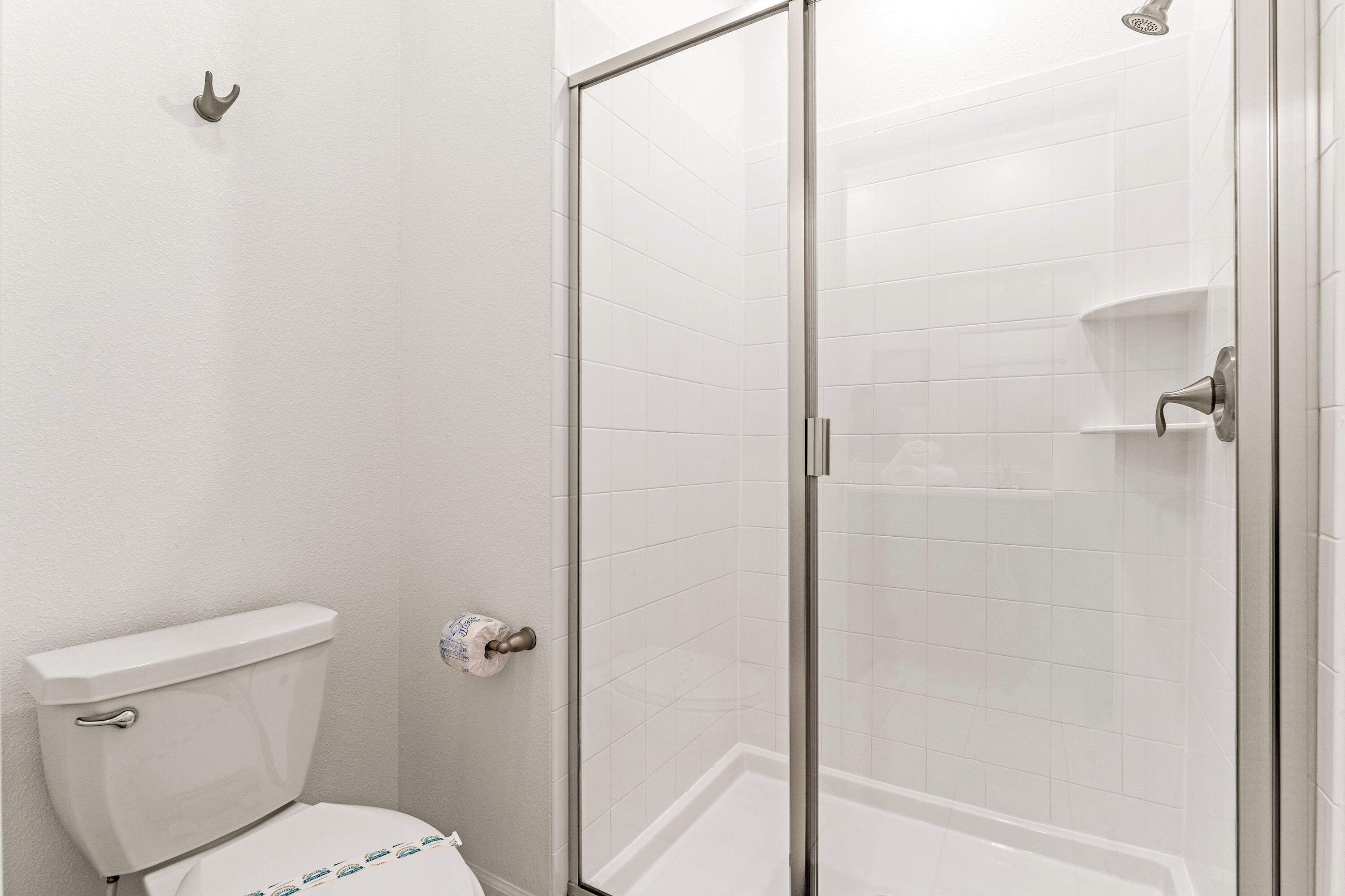 Ein Badezimmer mit Toilette, einer Duschkabine mit Glastür und einem Handtuchhalter.