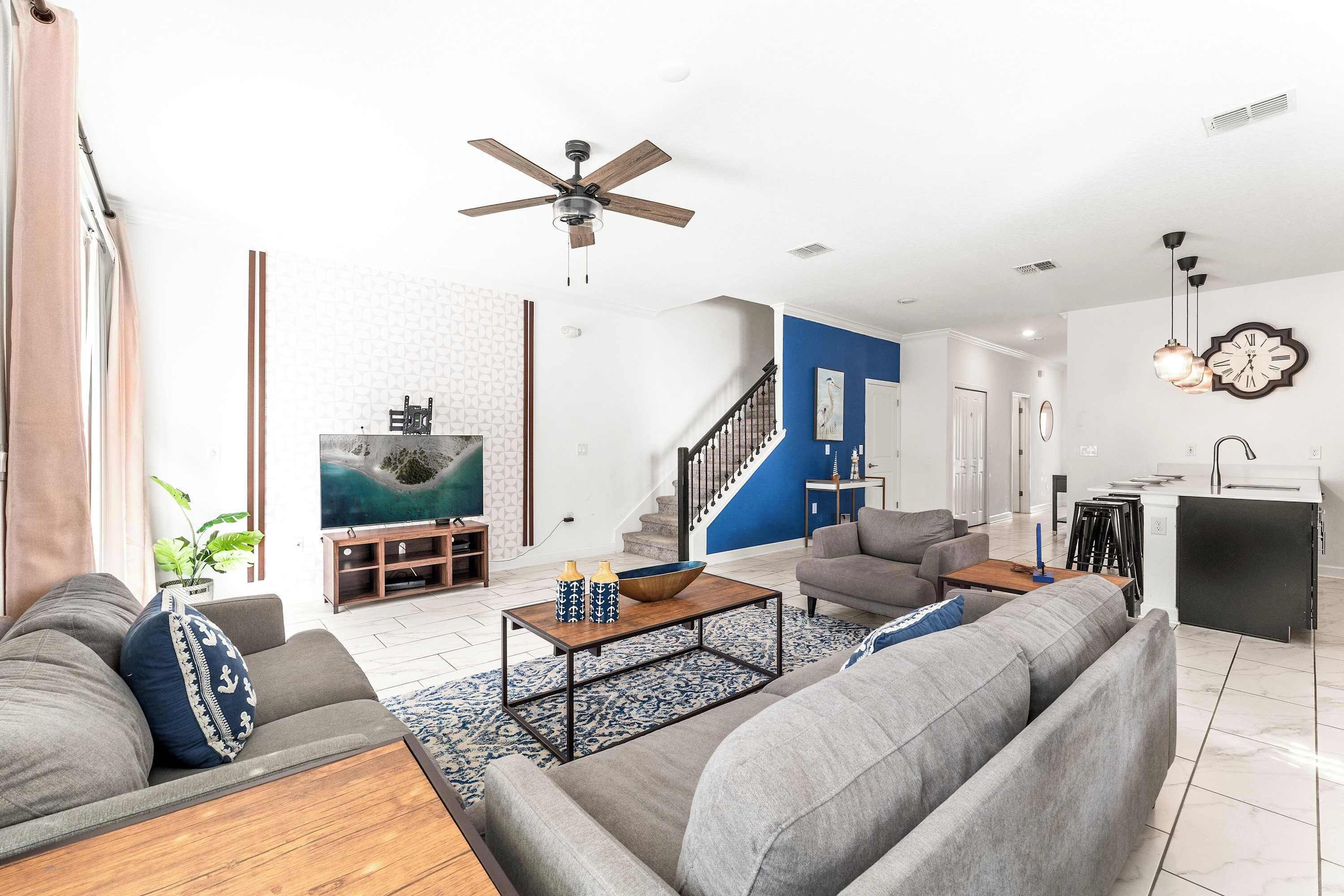 A modern living room with a sofa set, a coffee table, and a TV.