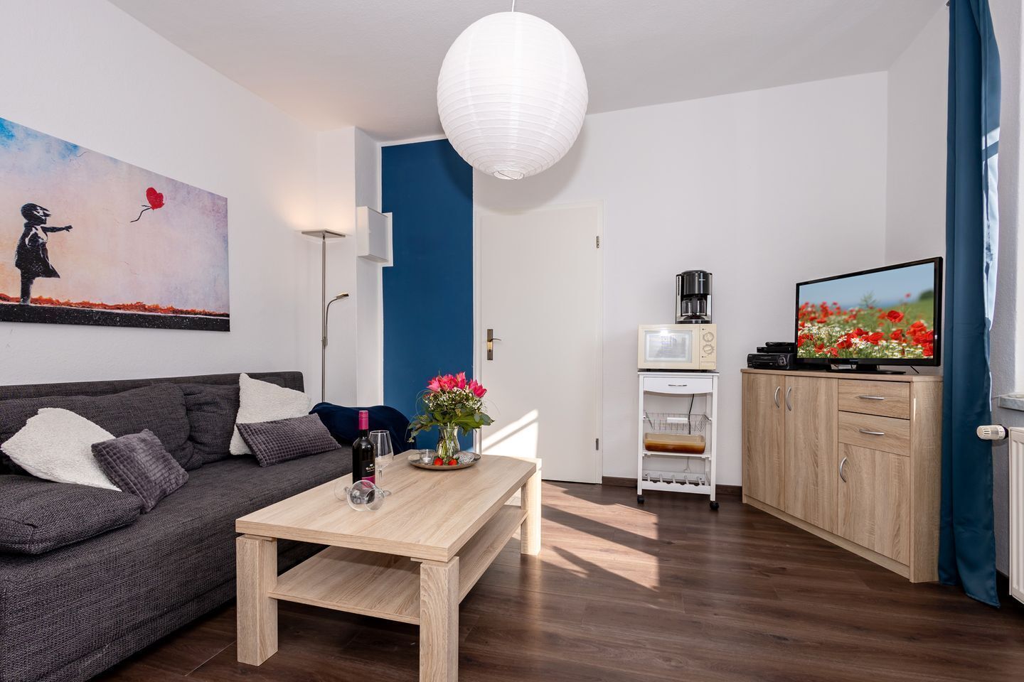 Una sala de estar moderna con un sofá, una mesita de centro y un cuadro en la pared.