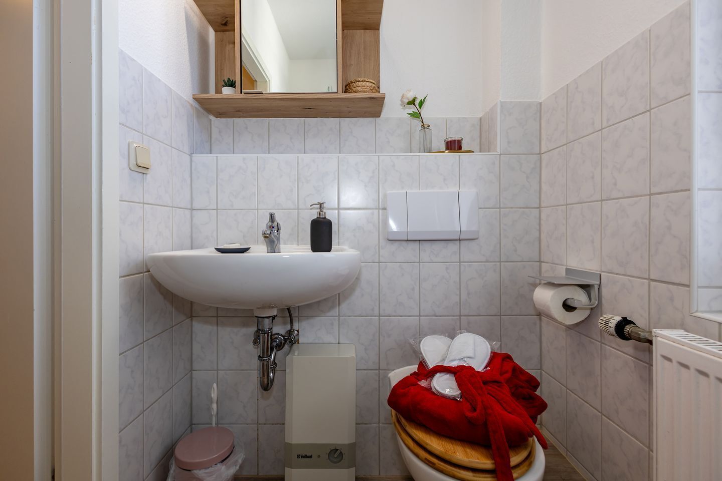 Une salle de bain avec un lavabo blanc, des toilettes et une douche.