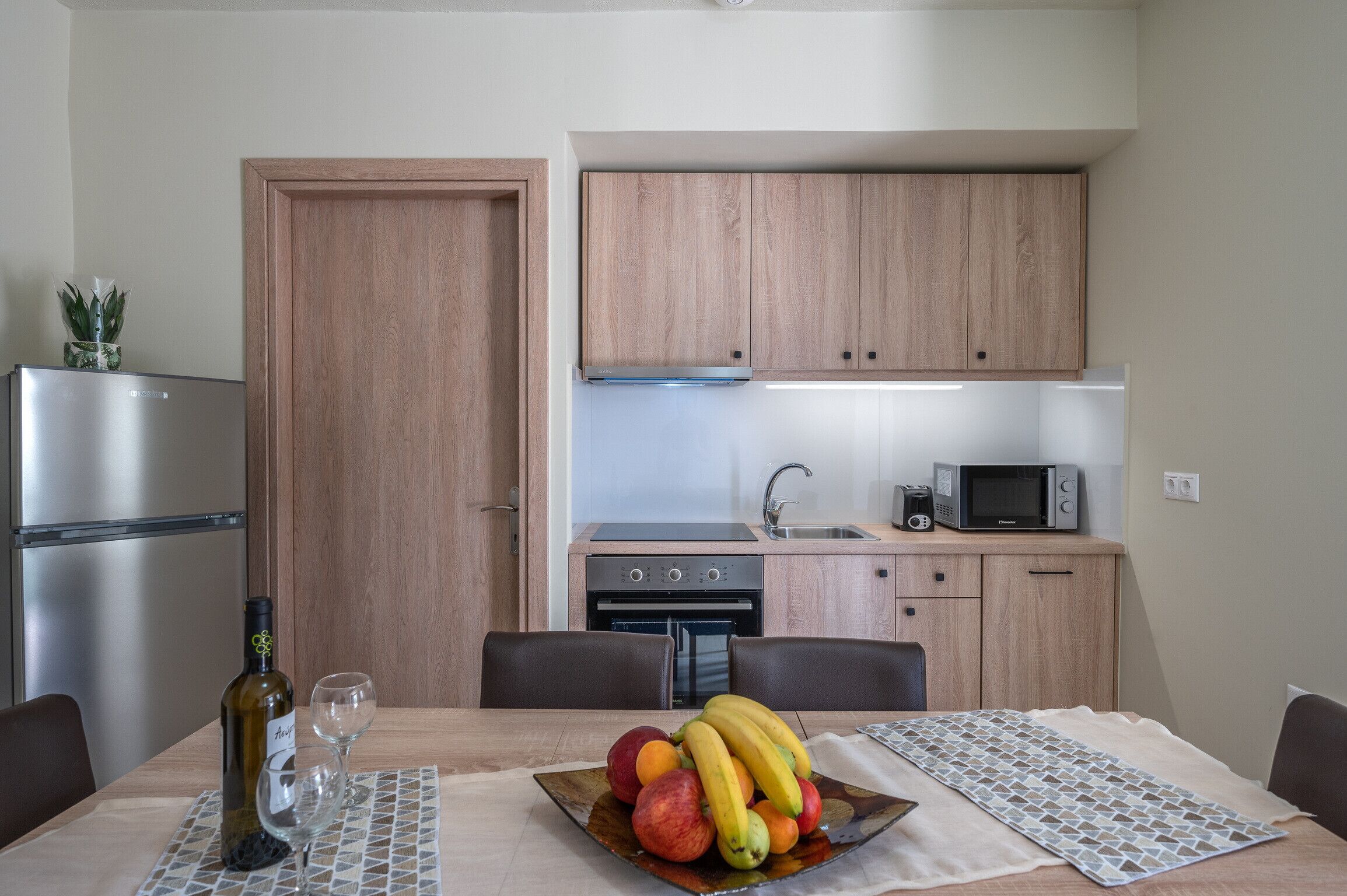 Una cocina compacta con armarios de madera, un microondas y un horno empotrado.