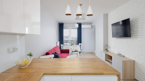 A modern kitchen with white cabinetry, a wooden countertop, and pendant lighting. - Spacious Apartment for 8 Persons | Air Conditioning | 2 Parking Spaces (Warszawa)