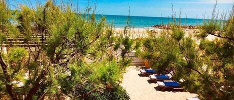 Rannalla, aurinkotuoleja, rantapyyhkeitä