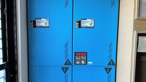 A blue storage unit with numbered compartments, each marked with a symbol and a number. - Popinn International Youth Hostel (Tainan)