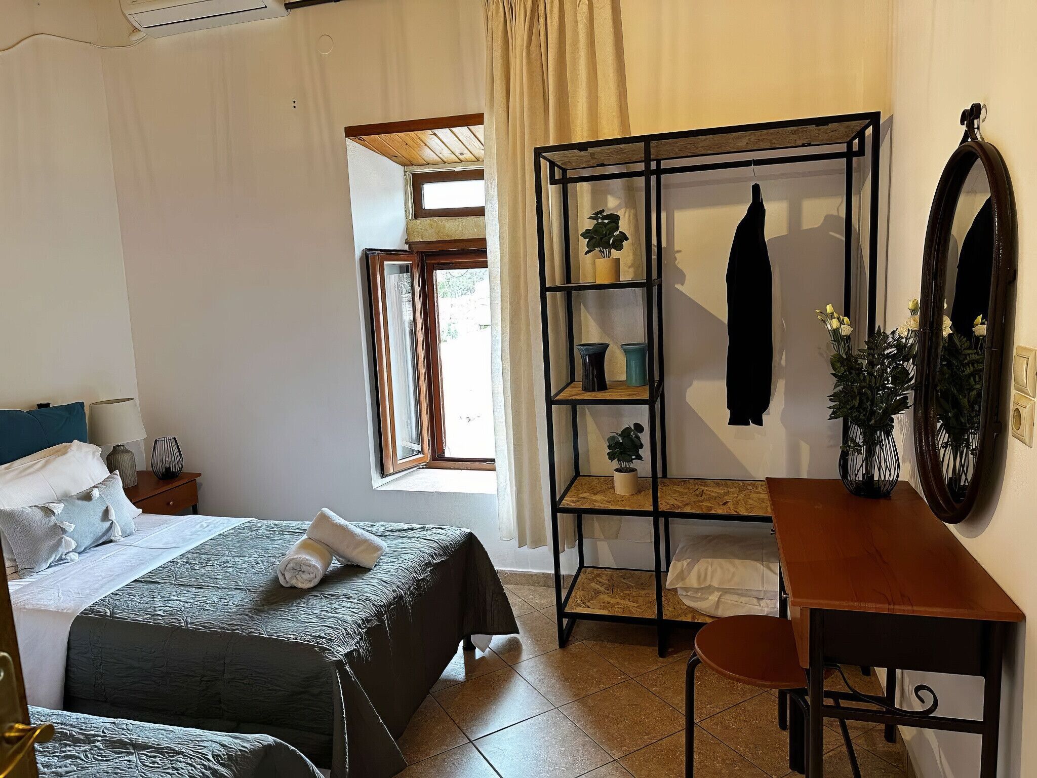 Une chambre à coucher comprenant un lit, un bureau, une chaise, une armoire et une fenêtre.