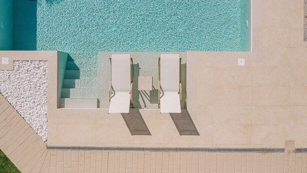 An aerial view of a swimming pool with two sun loungers and a pebble border. - Villa Panormo Crete (Mylopotamos)