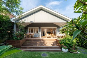 Una casa moderna con un porche cubierto, un comedor y un jardín cuidado.