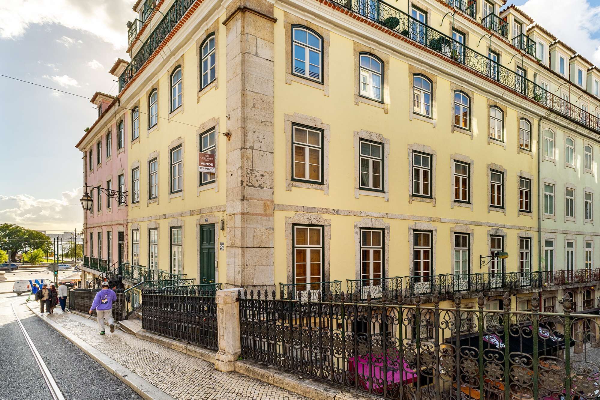 Monikerroksinen rakennus, jonka julkisivu on keltainen, siinä on useita ikkunoita ja parvekkeita, joissa on koristeelliset takorautakaiteet.