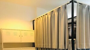 A room with a bunk bed, a wardrobe with multiple compartments, and a curtain divider. - Pie My Love (Vientiane)