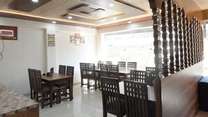 Uma sala de jantar com teto alto, cadeiras de madeira e uma mesa.