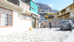 Um edifício com uma placa que diz "Vishnu Shala" e uma parede de pedra.