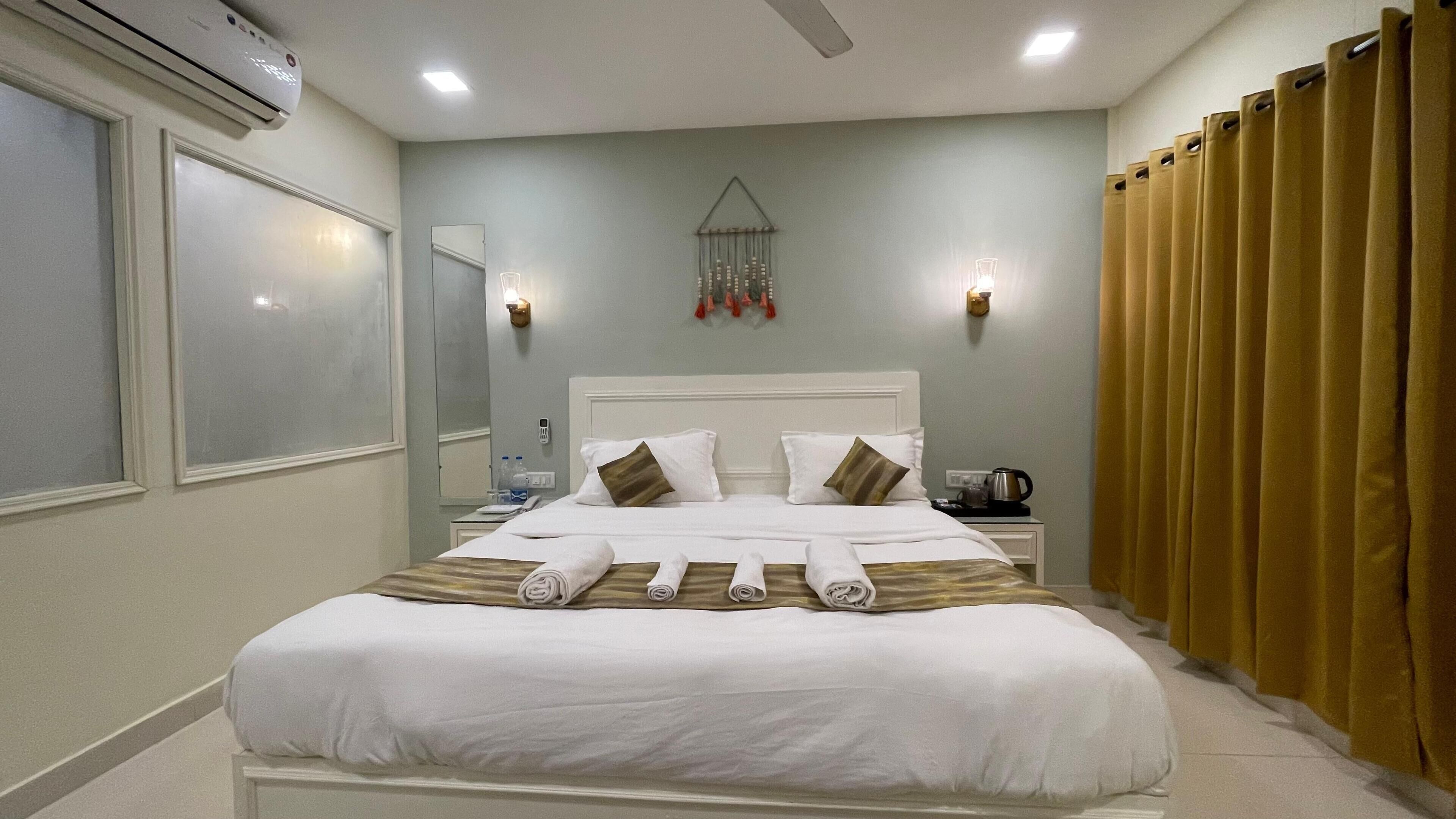 A hotel room with a bed, bedside table, and a nightstand.