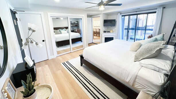 A modern bedroom with a large bed, a ceiling fan, a TV, and a sliding door leading to a bathroom. - Ski-In/Out Luxury / Central Location / King, Chef’s Kitchen / Park City Mtn Base (Park City)