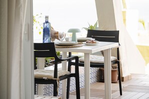A dining table with chairs, a bottle, plates, and a bowl. - Luxury apartment with pool and panoramic views. (Santa Ursula)