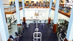 Ein Fitnessstudio mit unterschiedlichen Trainingsgeräten, darunter Laufbänder, Ergometer und Kraftgeräte.