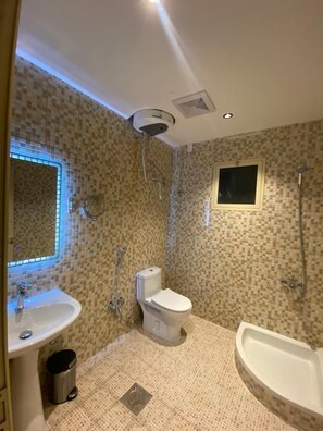 Een aparte badkuip en douche, een haardroger, handdoeken, zeep