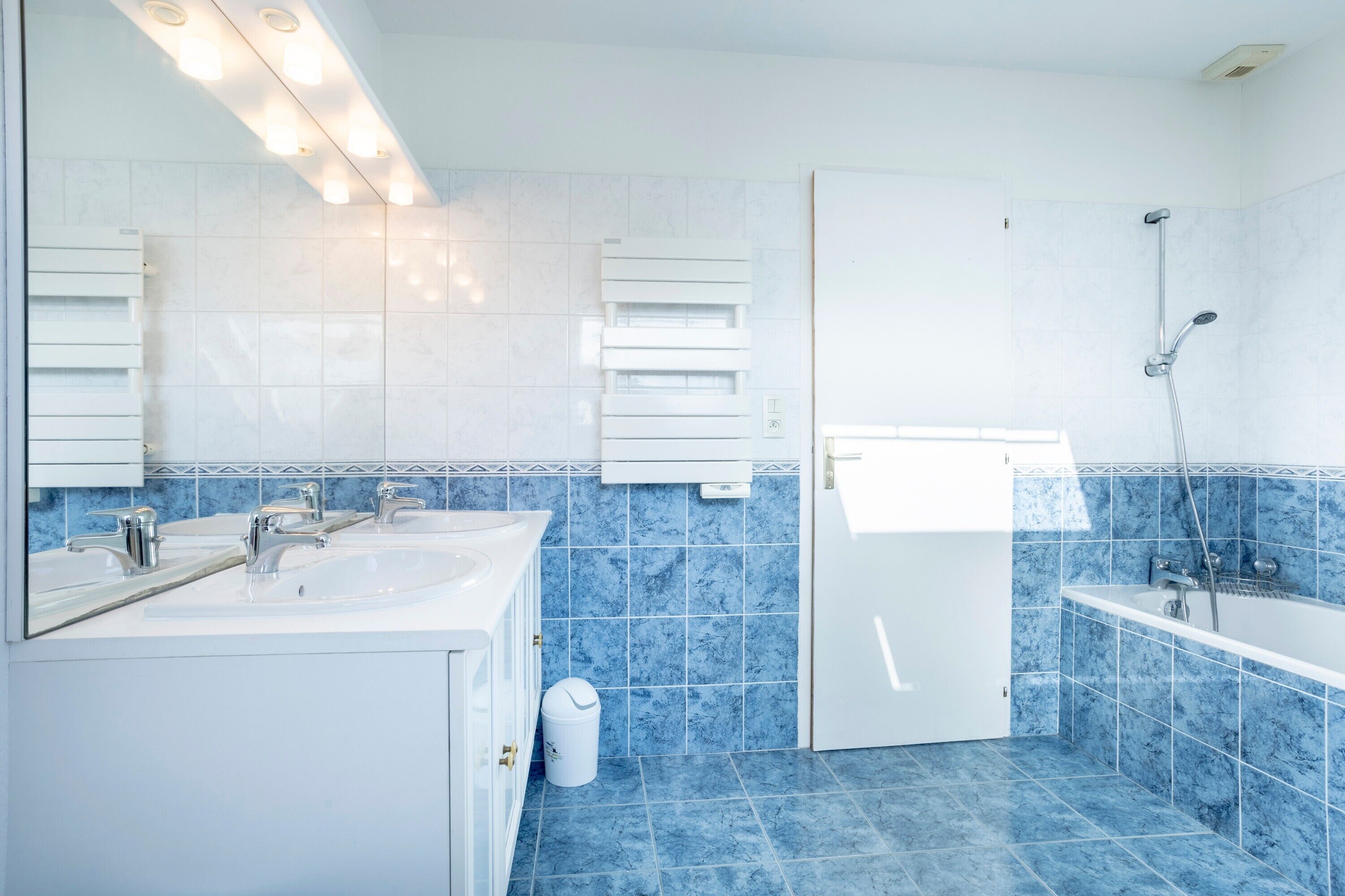 A modern bathroom with two sinks, a shower, and a toilet.