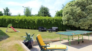 An outdoor area with a ping pong table, seating, and a slide. - Family Vacation Home in Bénodet (bénodet)