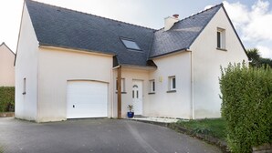 A two-story house with a garage, a small front porch, and a triangular roof. - Family Vacation Home in Bénodet (bénodet)