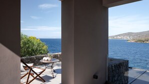 Een balkon met uitzicht op zee en een stenen muur.