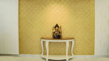 A statue on a white table against a textured wall.