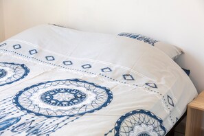 Tabla de planchar con plancha y ropa de cama