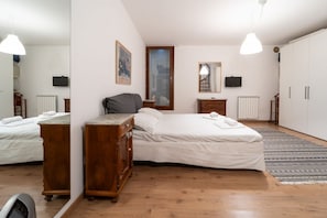 A bedroom with a bed, dresser, mirror, and a radiator.