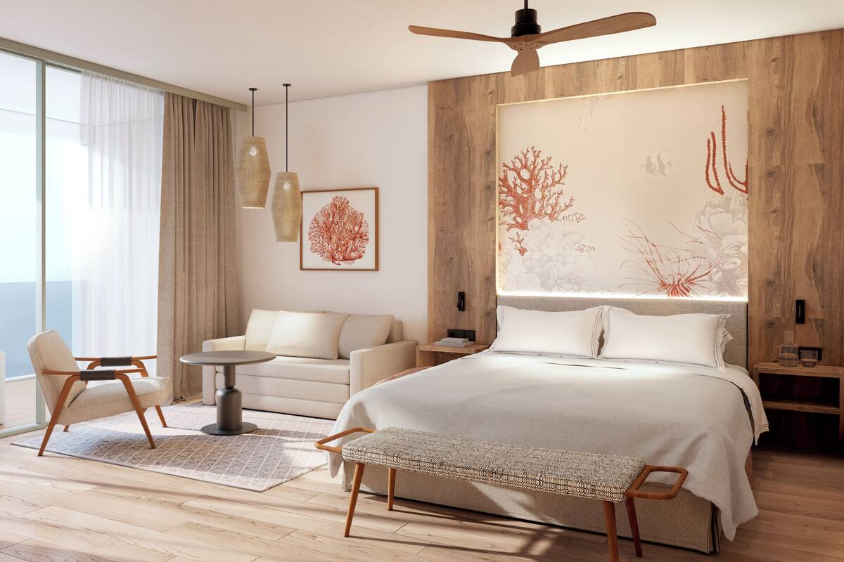 Une chambre moderne avec un grand lit, un bureau, une chaise et un canapé.