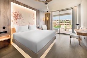 Habitación de hotel moderna con una cama grande, un escritorio y vistas a una piscina y un edificio.