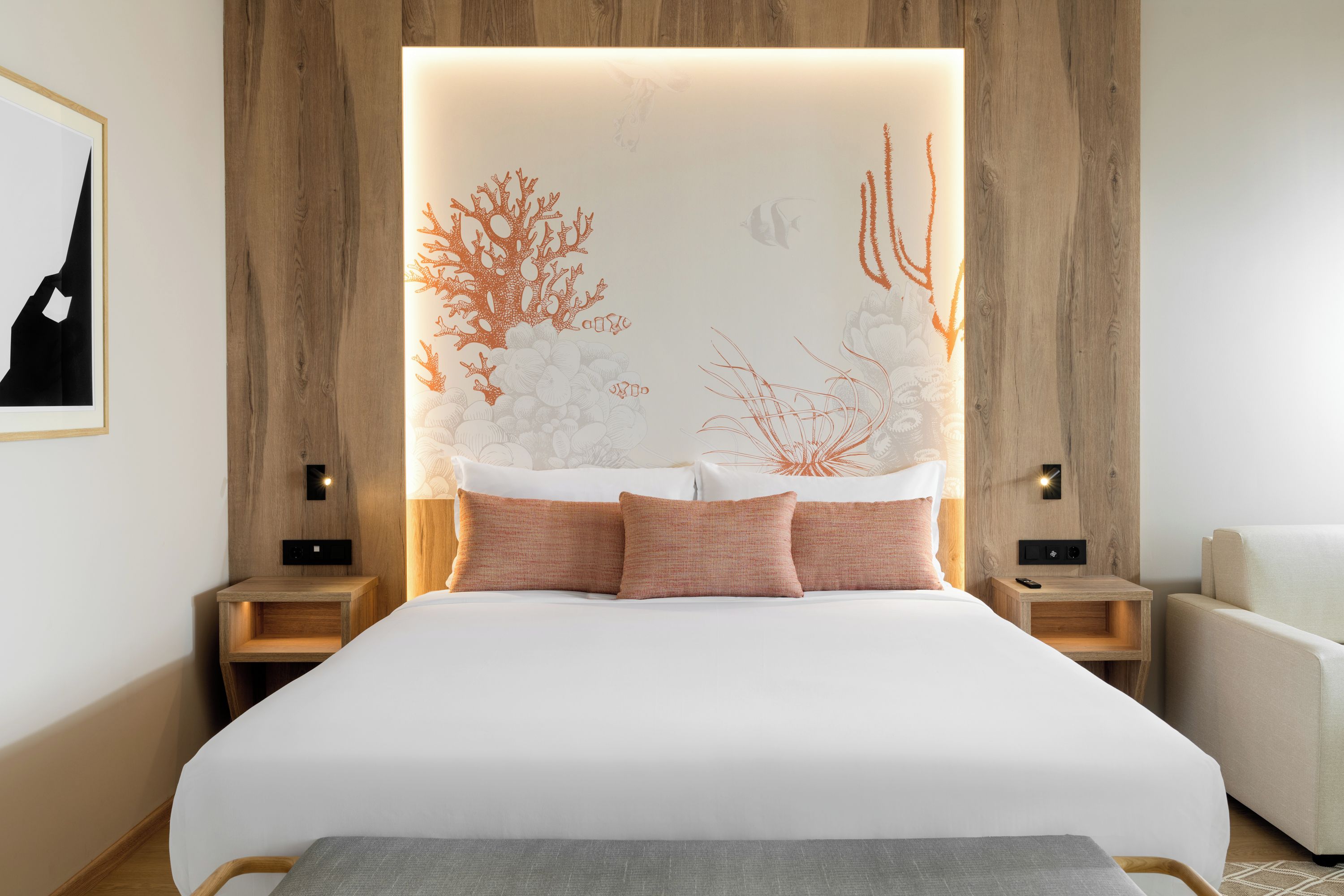 Un dormitorio moderno con una cama grande, cabecera de madera y dos mesitas de noche.