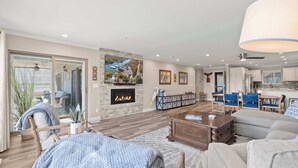 Una sala de estar amplia con chimenea, un comedor y una cocina.