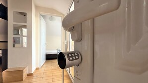 Et moderne interiør med trægulv, trappe og et panel til styring monteret på væggen.