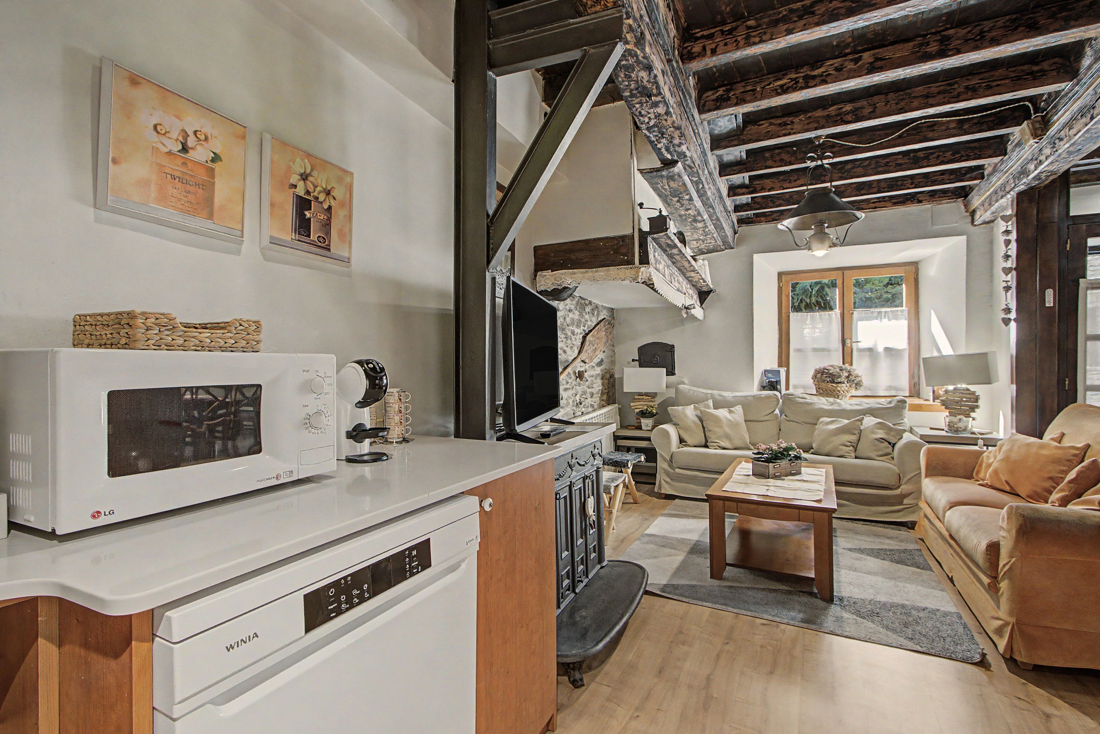 A modern living room with a white microwave, a wooden cabinet, a sofa, and a coffee table.