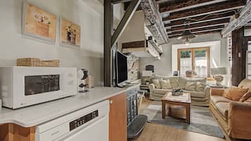 A modern living room with a white microwave, a wooden cabinet, a sofa, and a coffee table.