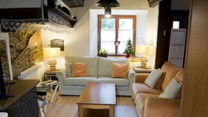 Ein gemütliches Wohnzimmer mit einer Couch, einem Couchtisch und einem Kamin.