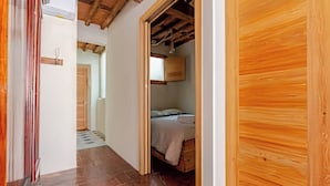 A bedroom with a wooden ceiling, a bed, and a wooden wardrobe. - Apartment in the Historic Center of Pietrasanta (Pietrasanta)