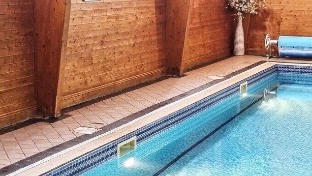 An indoor swimming pool with wooden walls and a tiled floor. - Hunters Meet Ltd  (Hatfield Heath)
