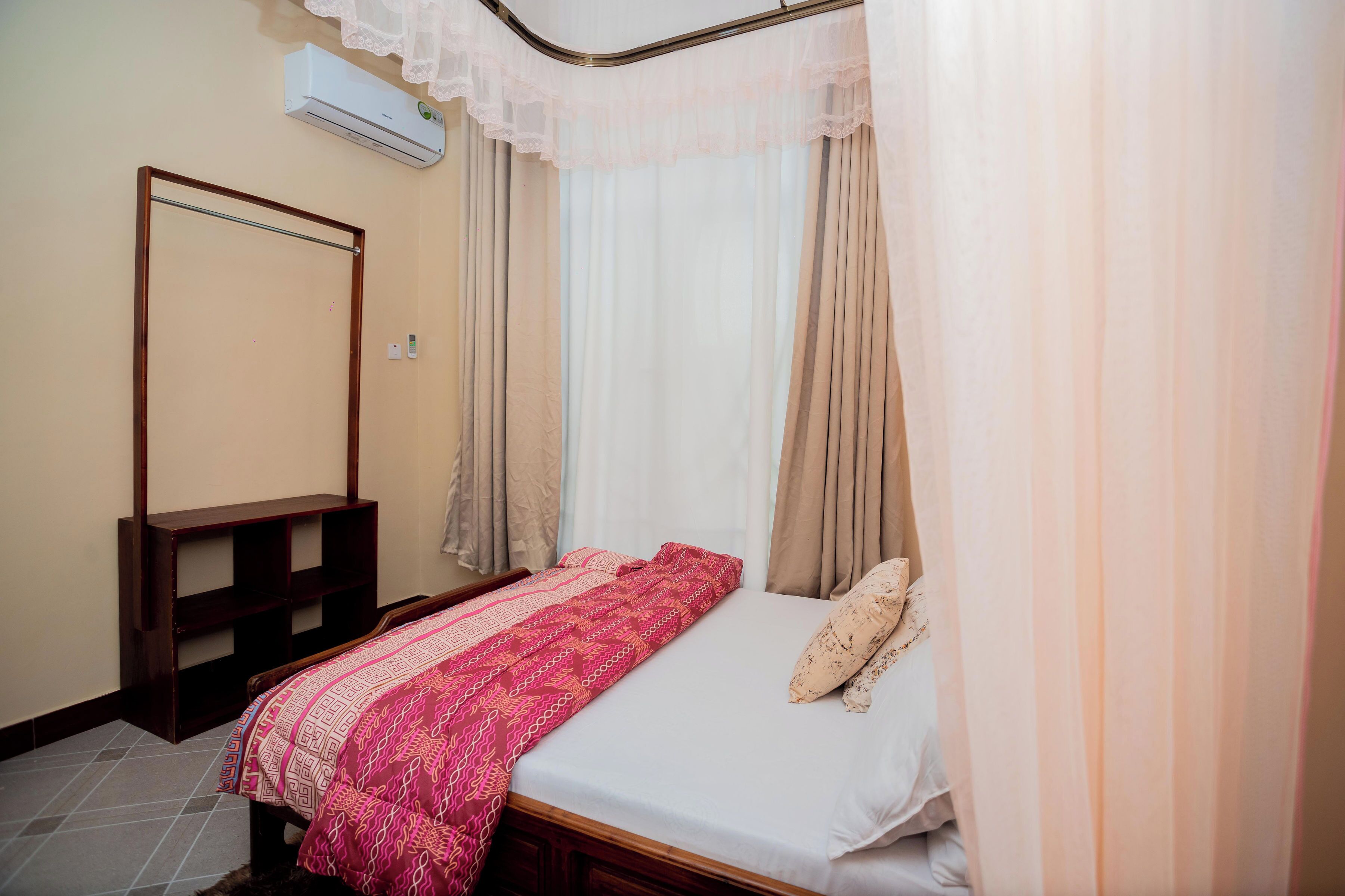 Une chambre à coucher avec un lit, une tête de lit en bois, une table de chevet et un miroir.