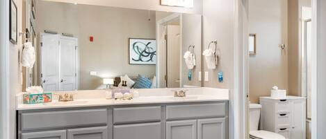 A modern bathroom with a large vanity, double sinks, and a toilet.