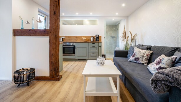 Ein modernes Wohnzimmer mit einer Couch, einem Couchtisch und einer Holzwand.