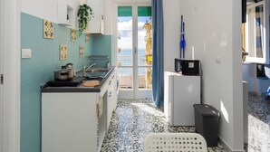 Una cucina compatta con piastrelle a parete, un lavello e un forno a microonde.