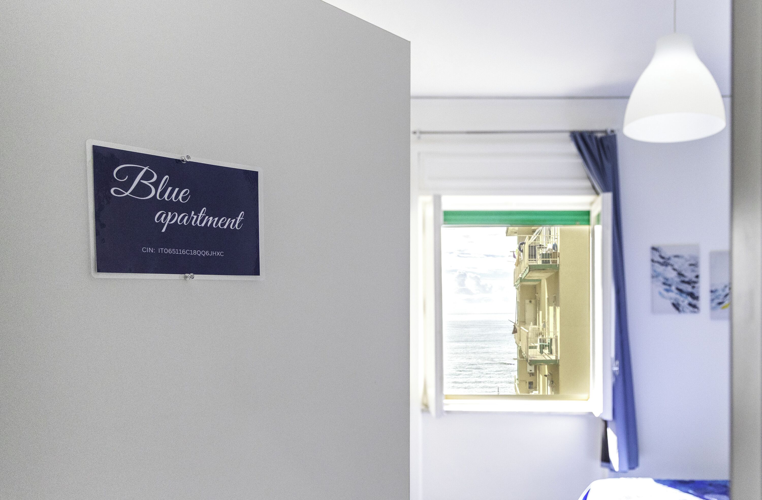 A room with a sign reading "Blue apartment" and a window with a view of buildings.