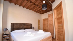 Ein Schlafzimmer mit einem hölzernen Bett, einem Nachttisch mit Lampe und Holzschränken.