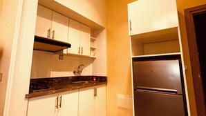 A compact kitchen with white cabinets, a black countertop, and a stainless steel refrigerator. - Relax family Majestic (Ouarzazate)